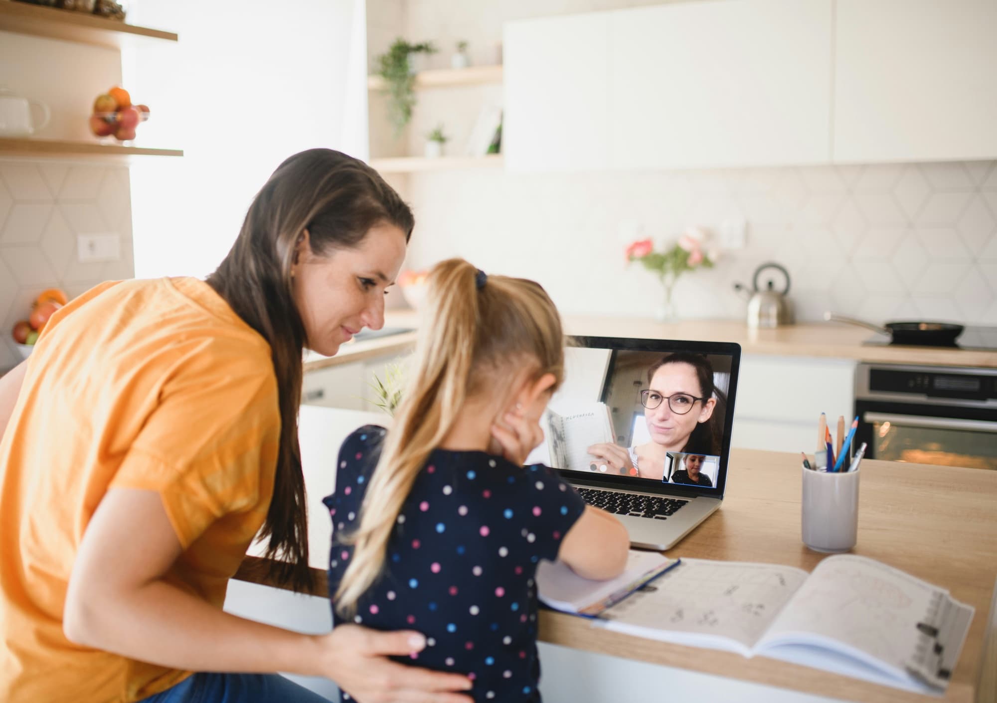 A parent and child at home on a video call with a SEND specialist who is showing notes on screen.